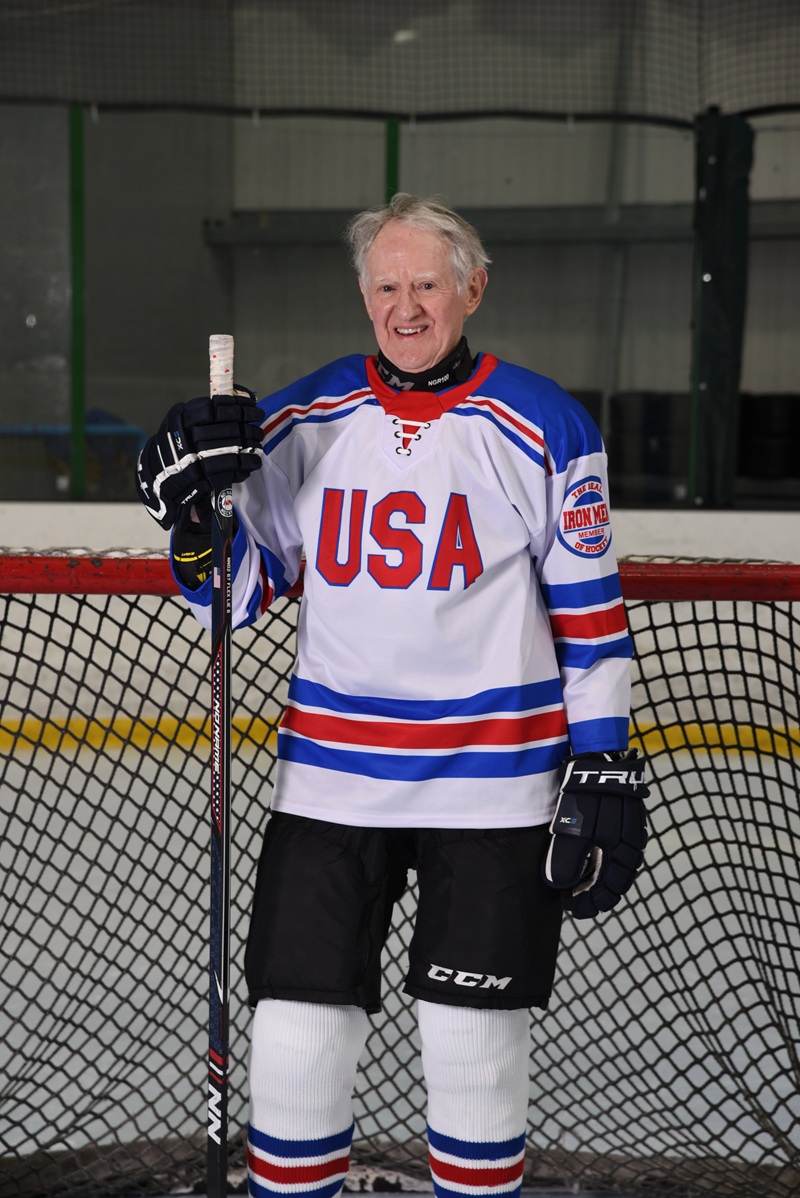 Fred Merchant in his USA jersey leaning on his stick at the net