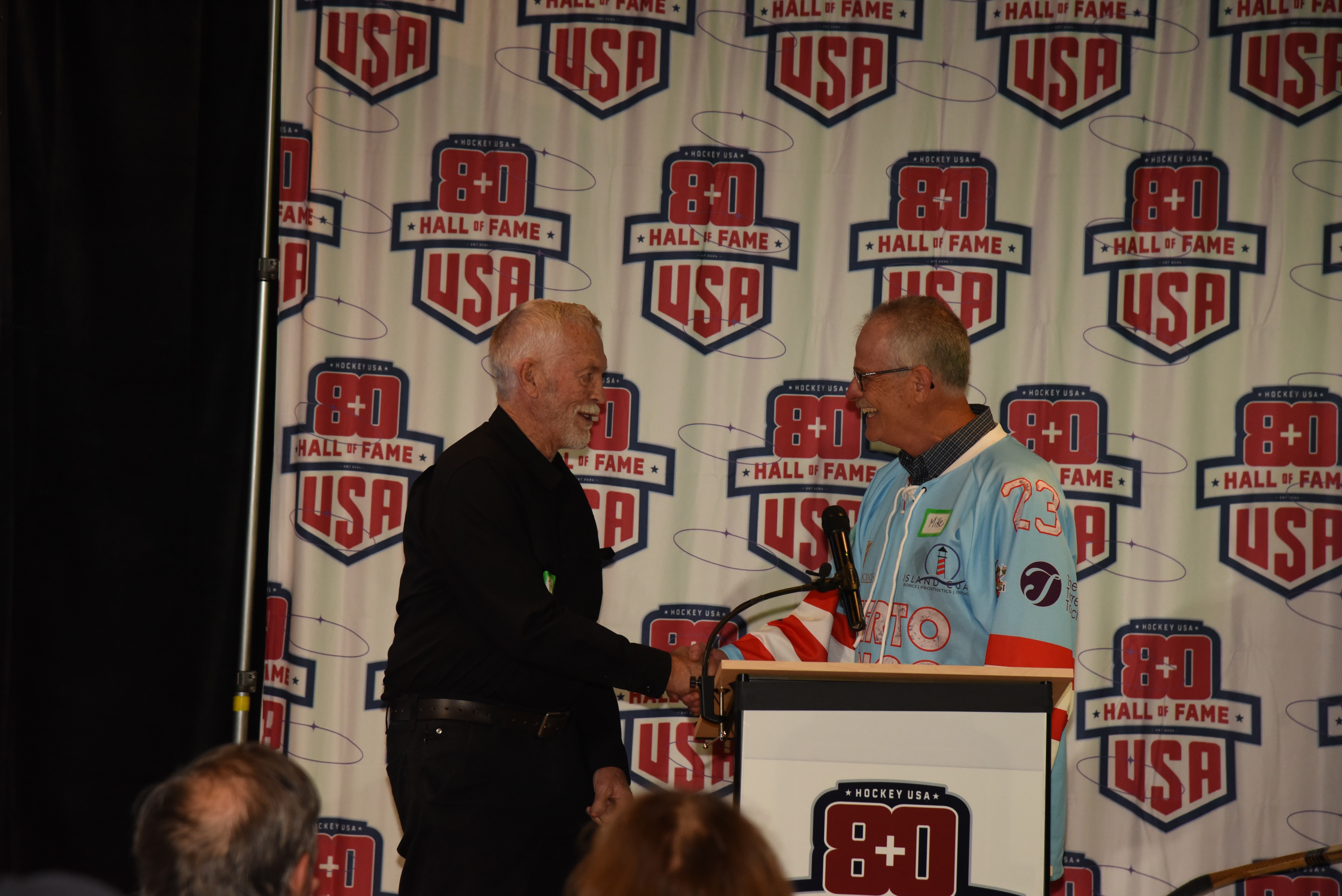 Terry Harper during his 2025 USA 80+ Hockey Hall of Fame induction handshake moment
