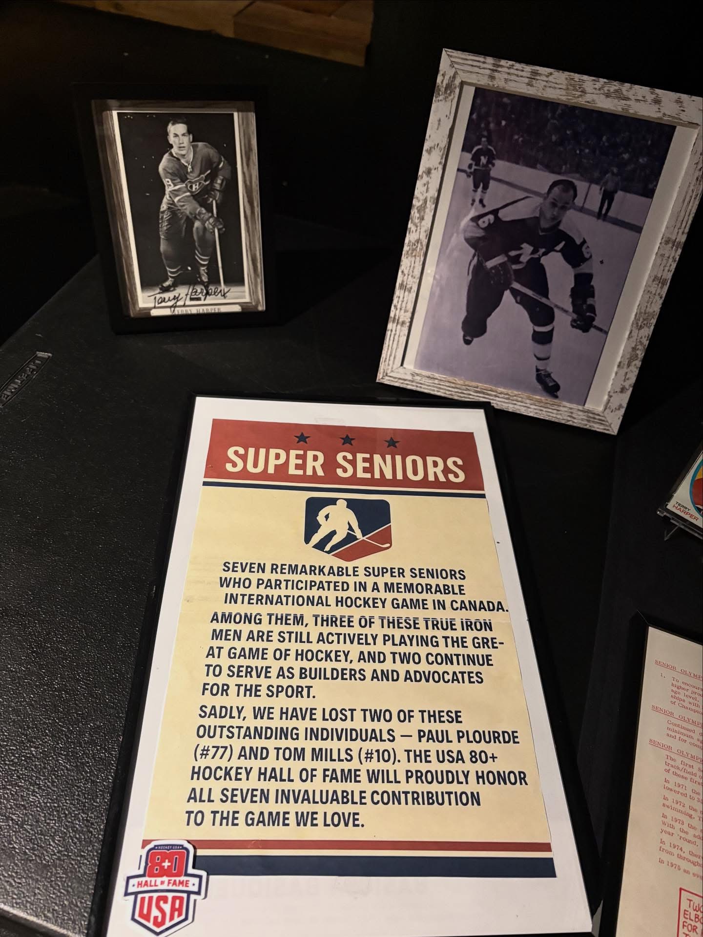 Super Seniors display with hockey memorabilia and Terry Harper photos at the 2025 Induction Ceremony